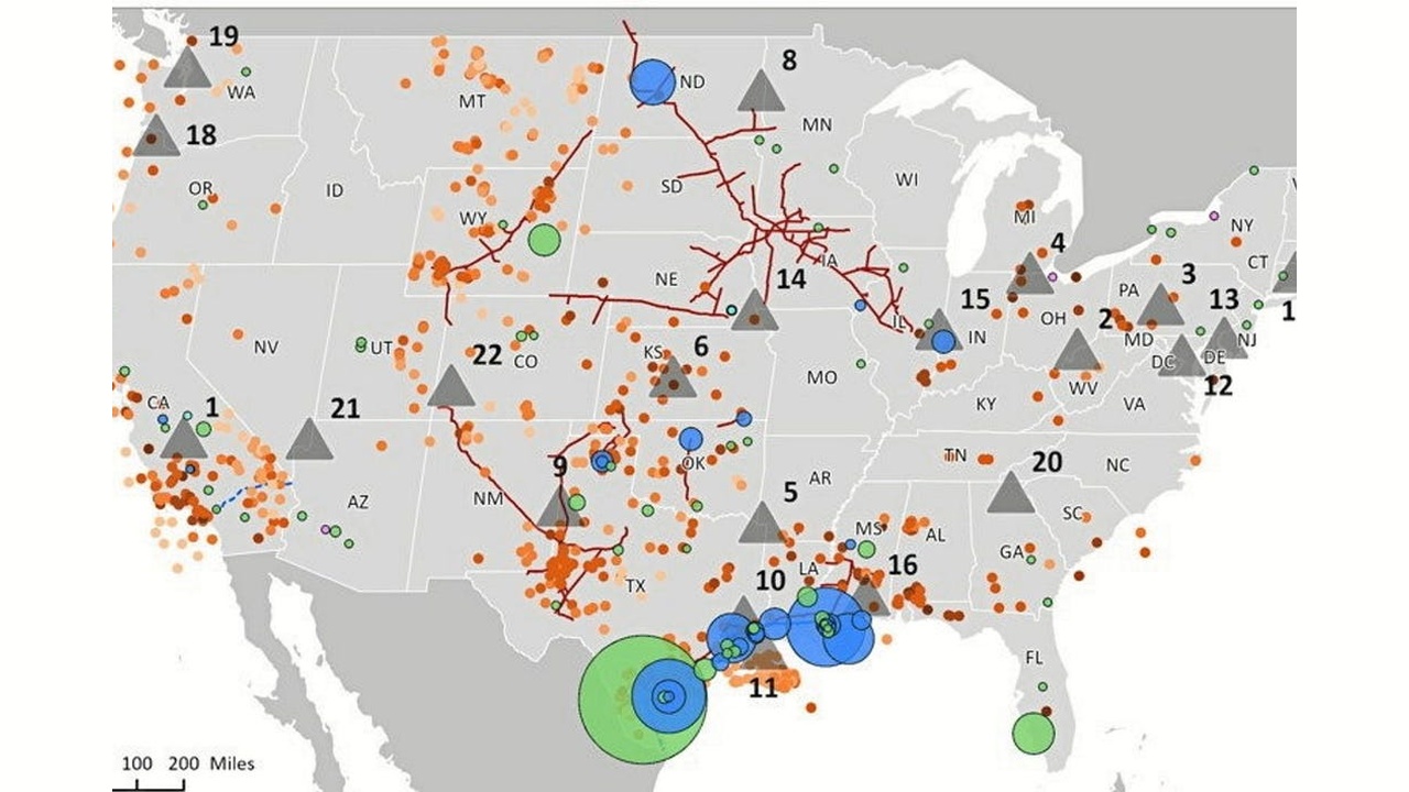 Map of the United States with colored markers: orange dots, blue and green circles, red fault lines, and gray triangles marking various geological features or events.