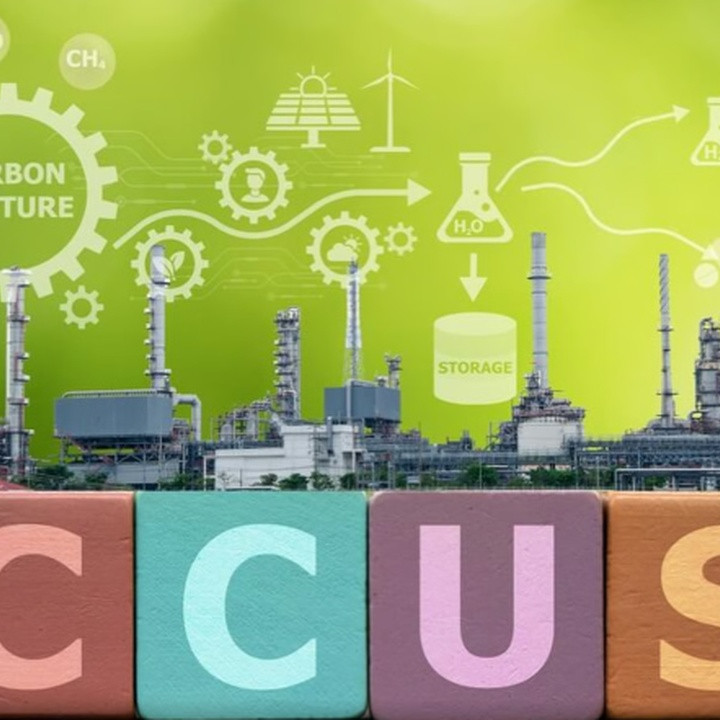 Industrial plant with colorful blocks spelling CCUS in the foreground and a carbon capture diagram in a green background, illustrating CCUS technology concept.